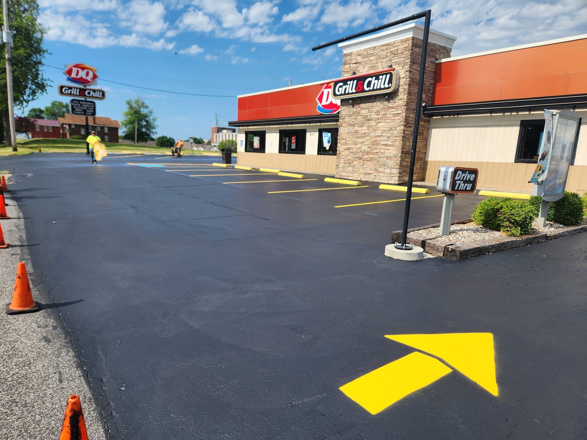 A yellow arrow is painted on the asphalt in front of a restaurant