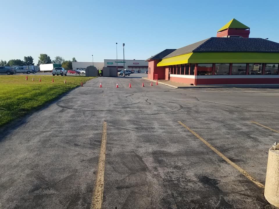 An empty parking lot with a restaurant in the background.
