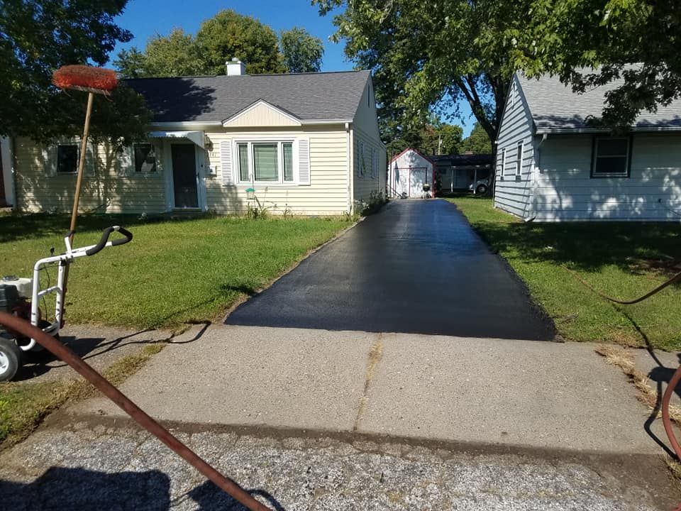 A driveway is being paved in front of a house.
