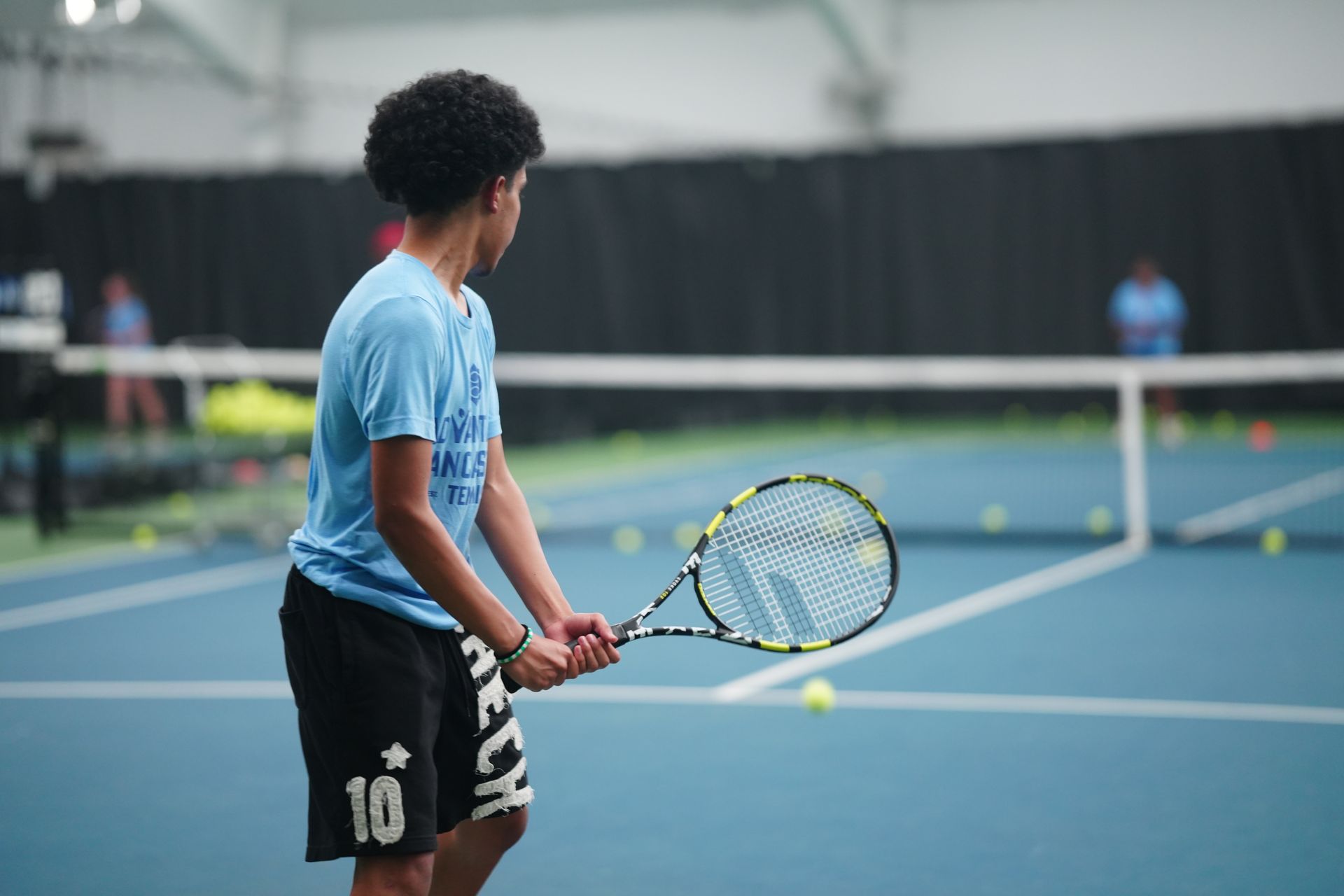A group of people are playing tennis on a court