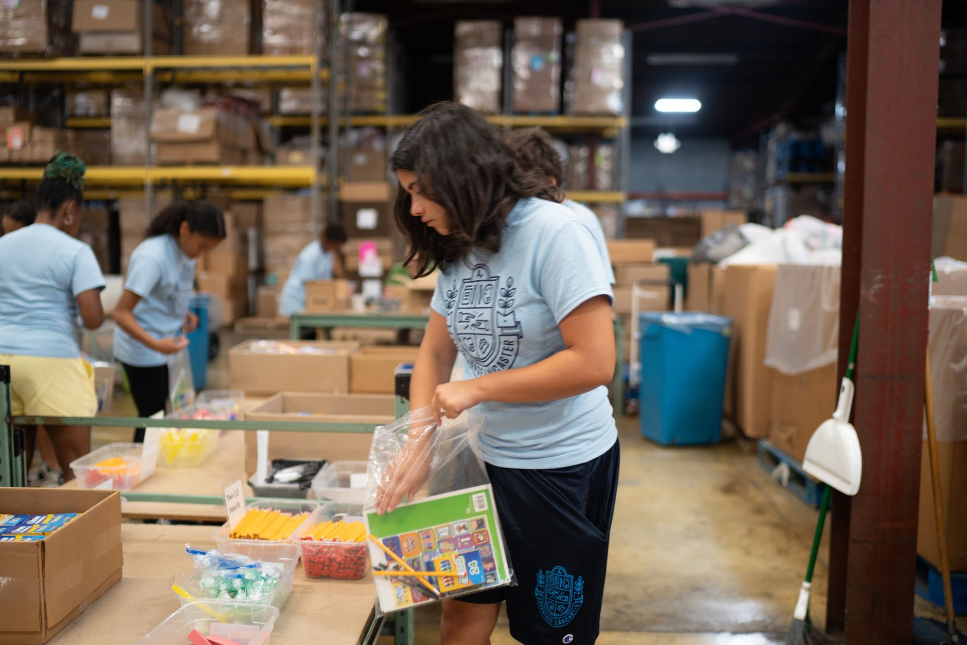 A woman is standing in a warehouse holding a book.