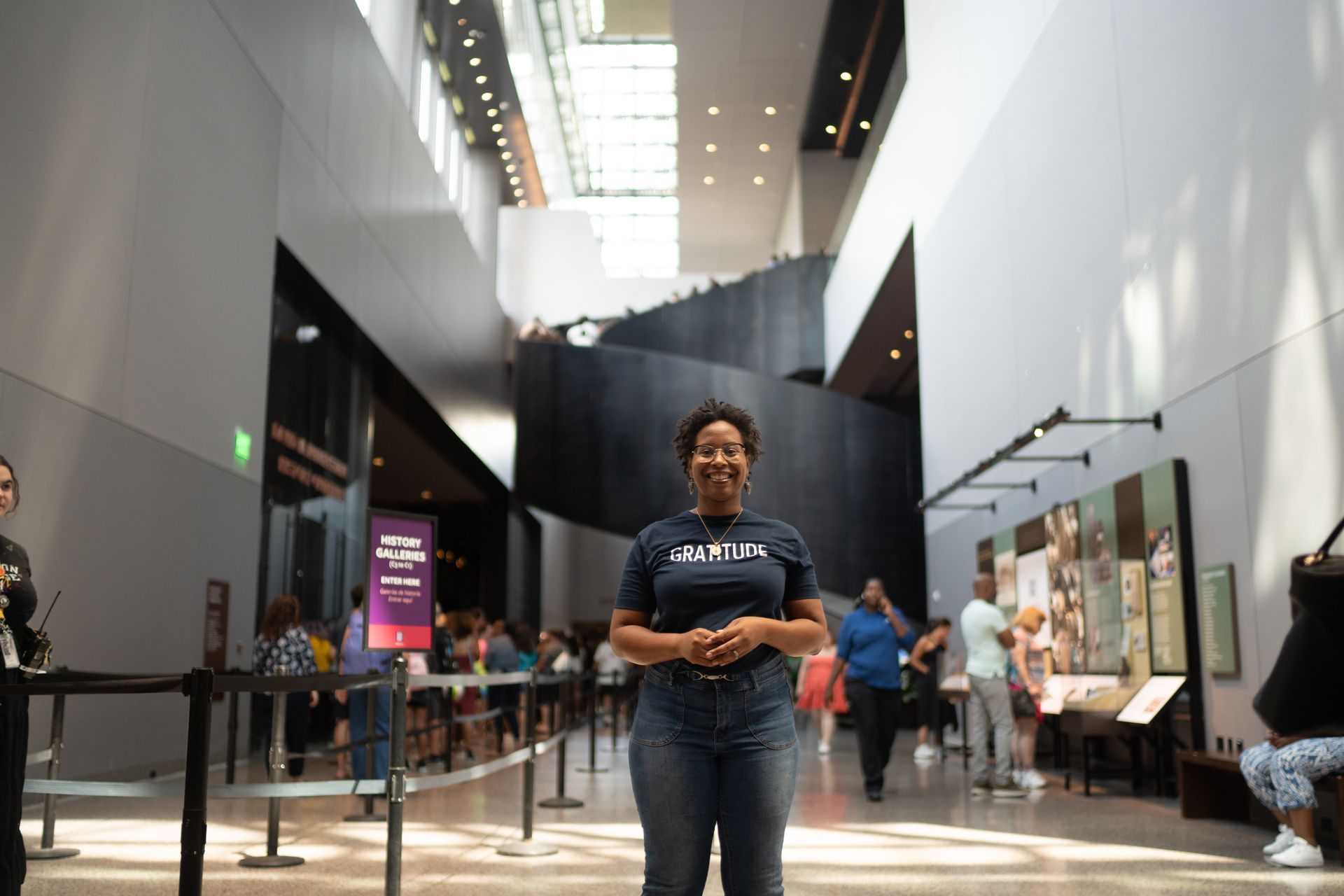 A woman is standing in the middle of a large building.