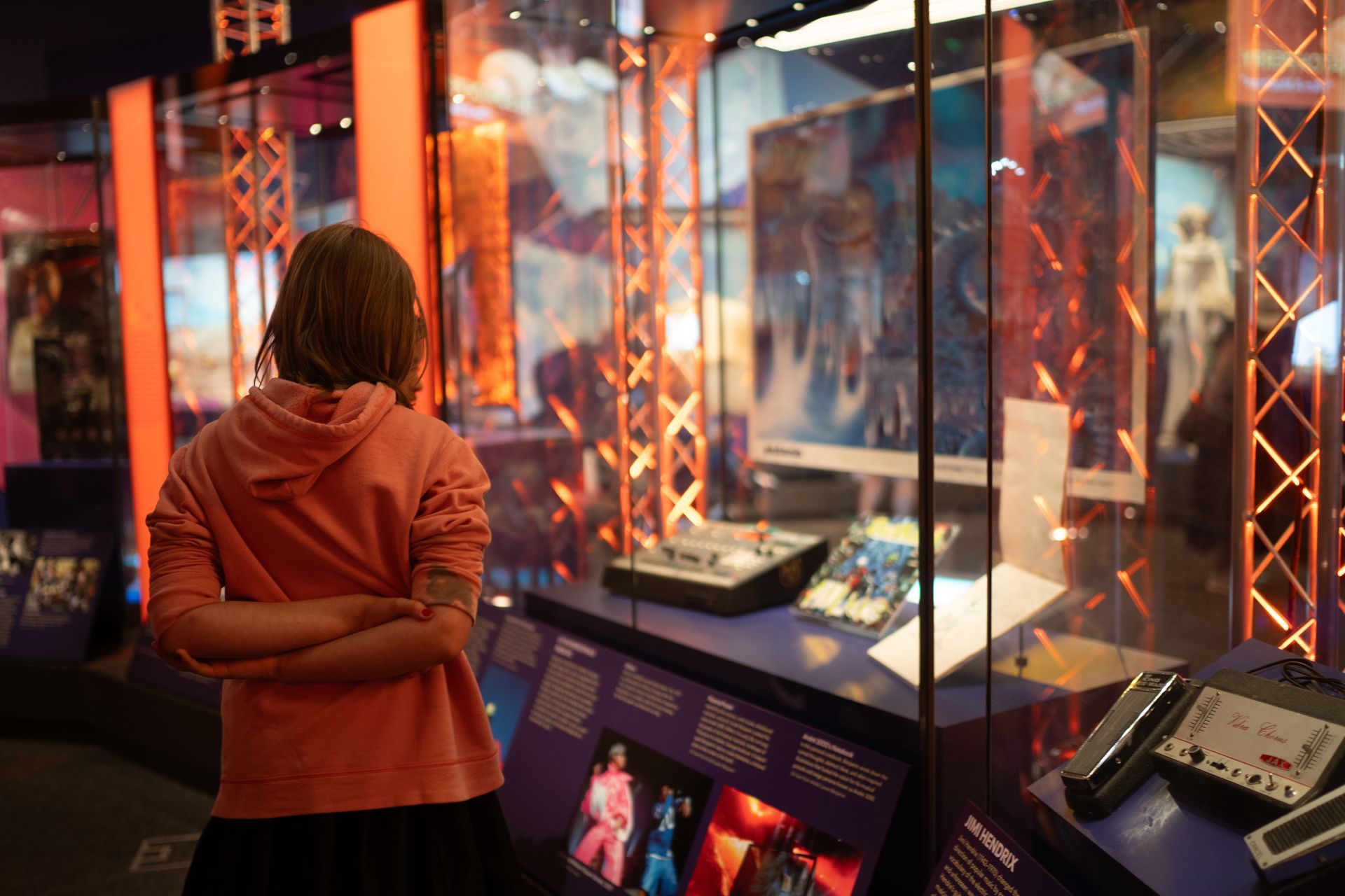 A young girl is looking at a display case in a museum.