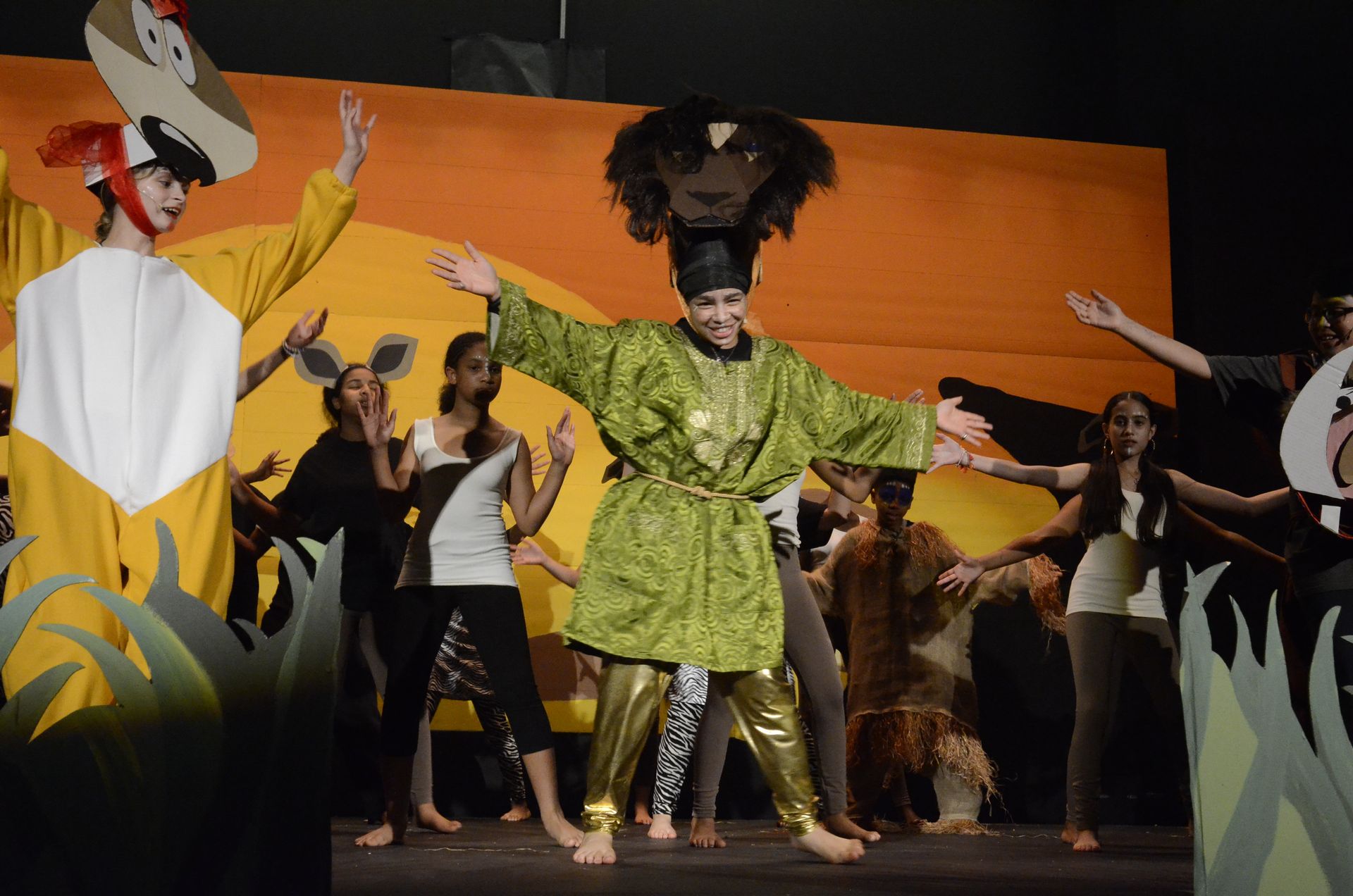 A group of people in costumes are dancing on a stage.