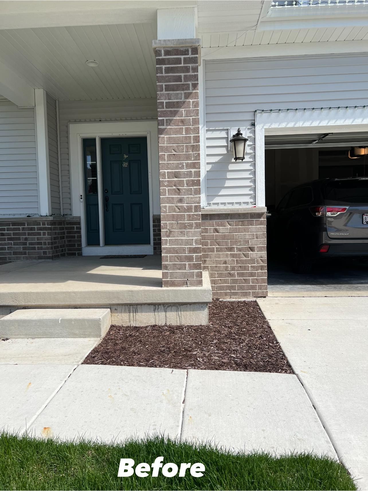 A before picture of a house with a car parked in the garage.