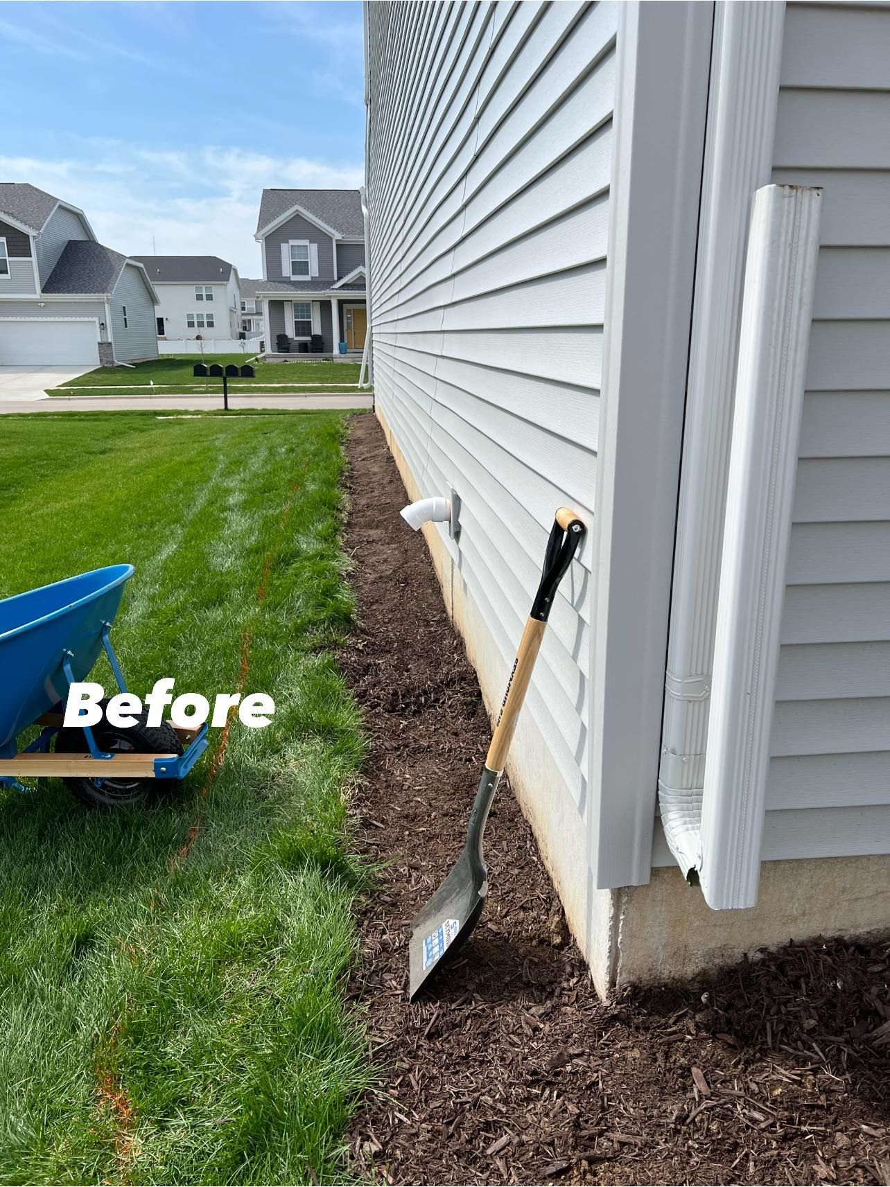 A shovel is leaning against the side of a house.