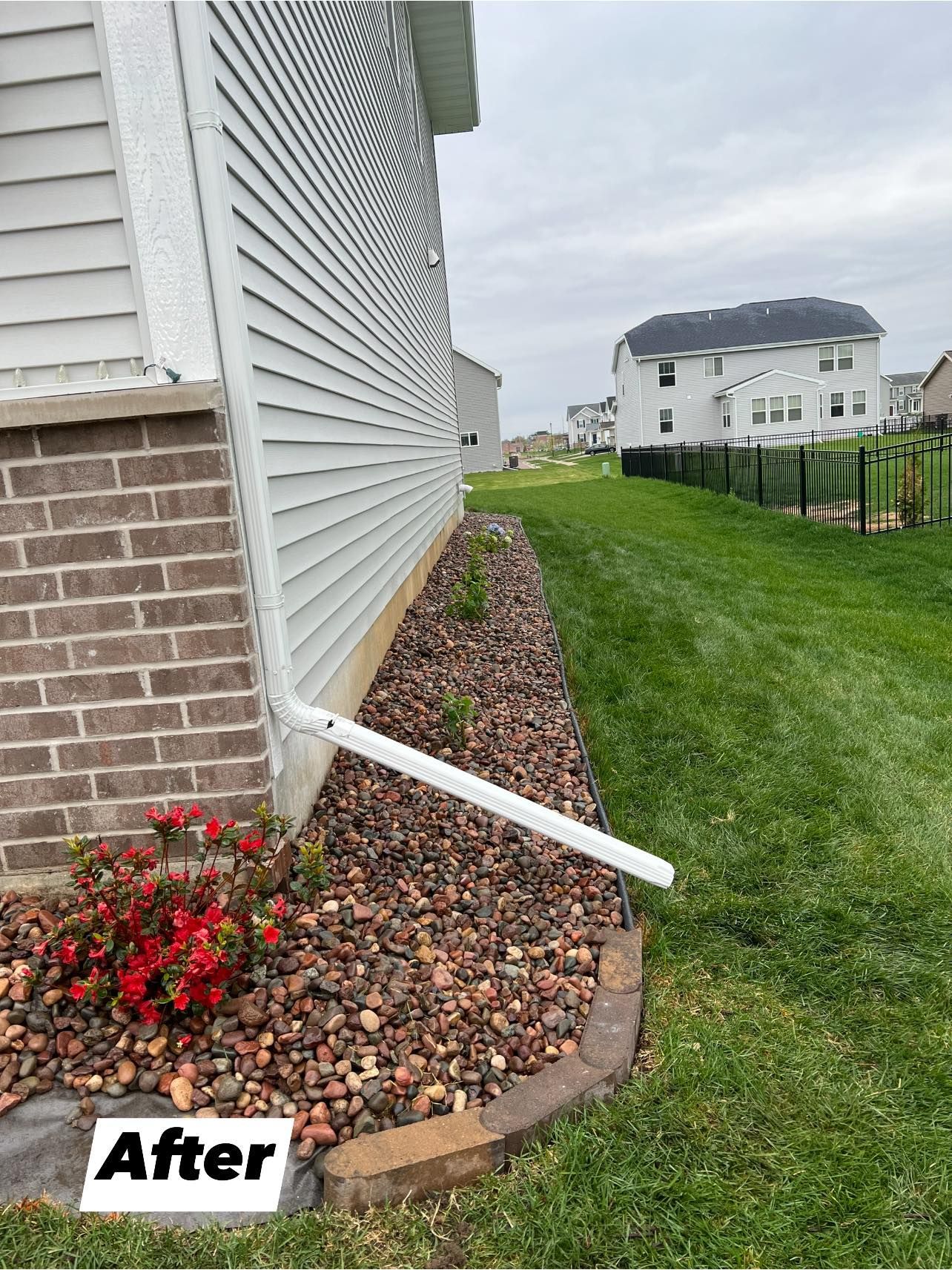 A picture of a house with a drain pipe in the yard.