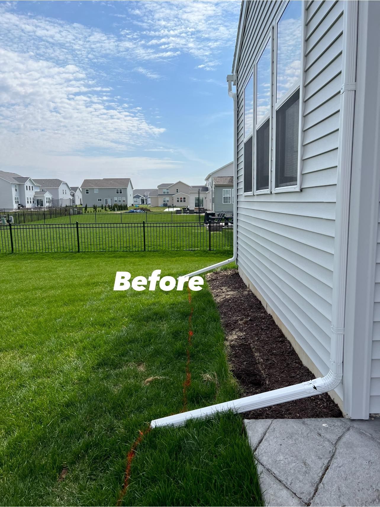 A picture of a house with a drain pipe on the side of it.