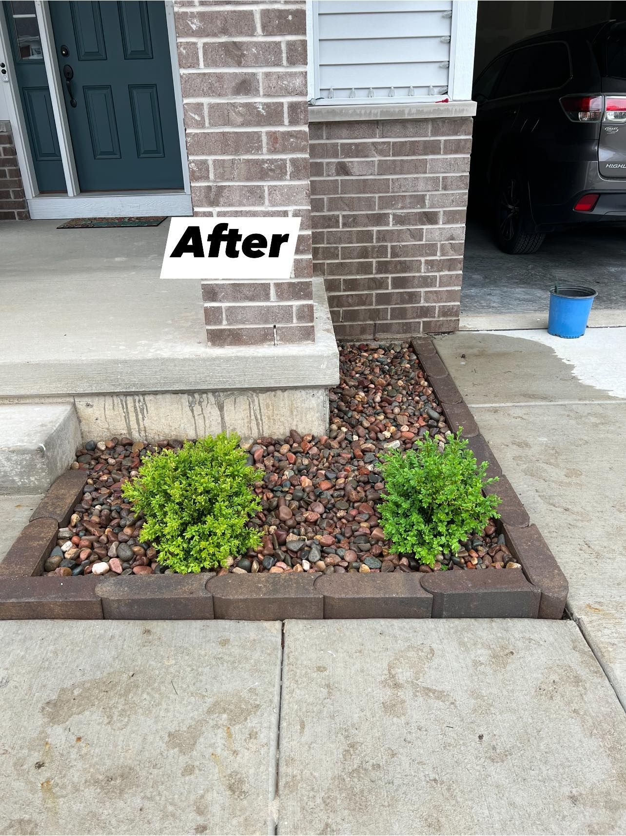 A picture of a garden in front of a brick house.