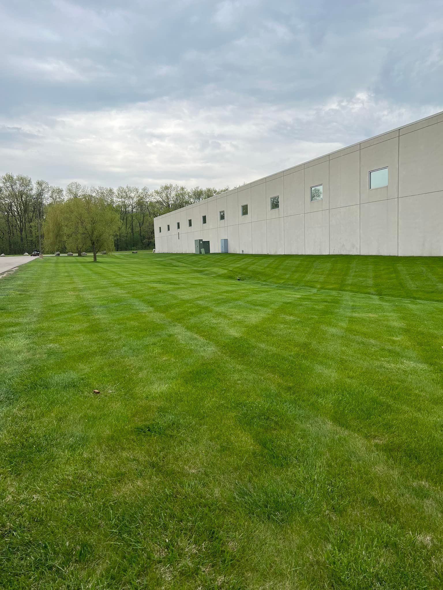 A large white building with a lush green lawn in front of it.