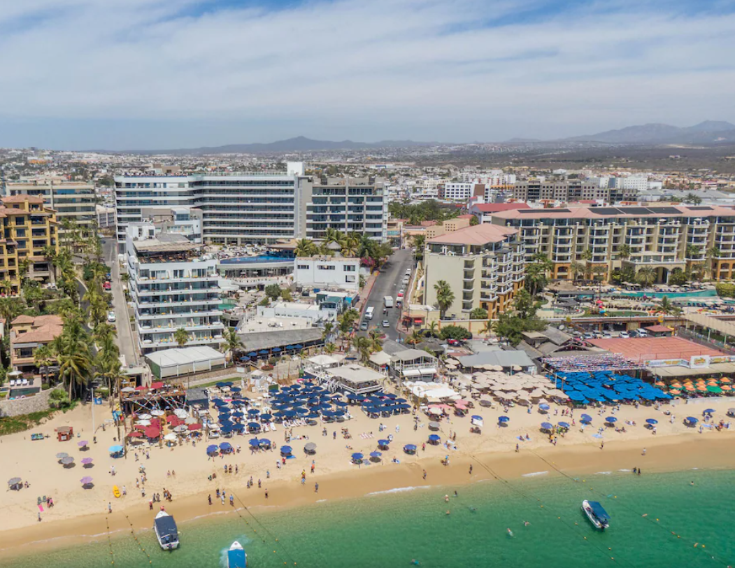 An aerial view of a beach filled with people and boats.