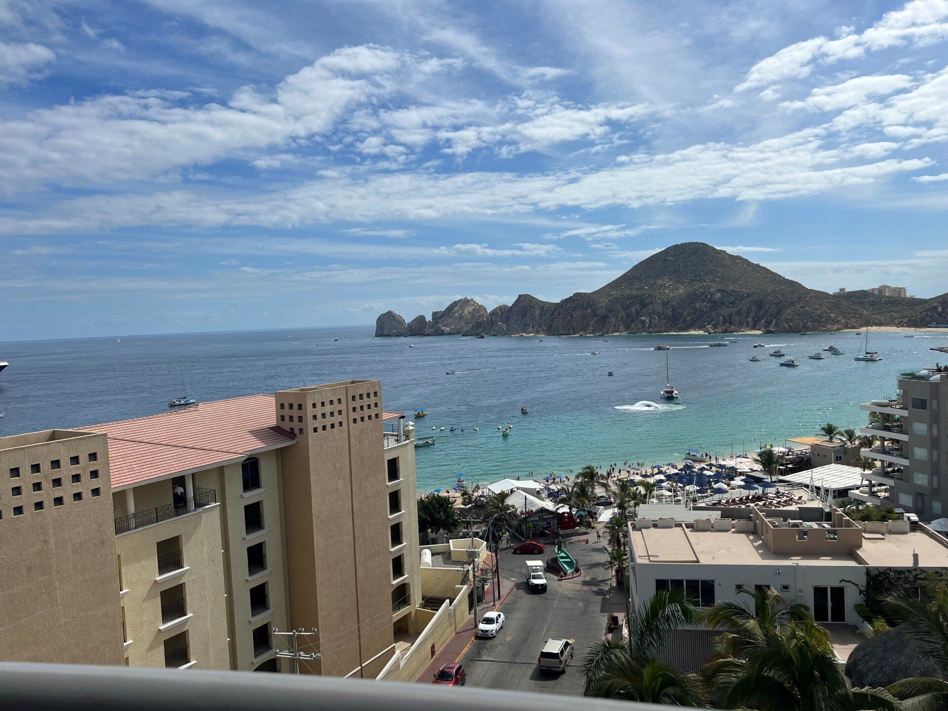 A view of the ocean from a balcony with a mountain in the background