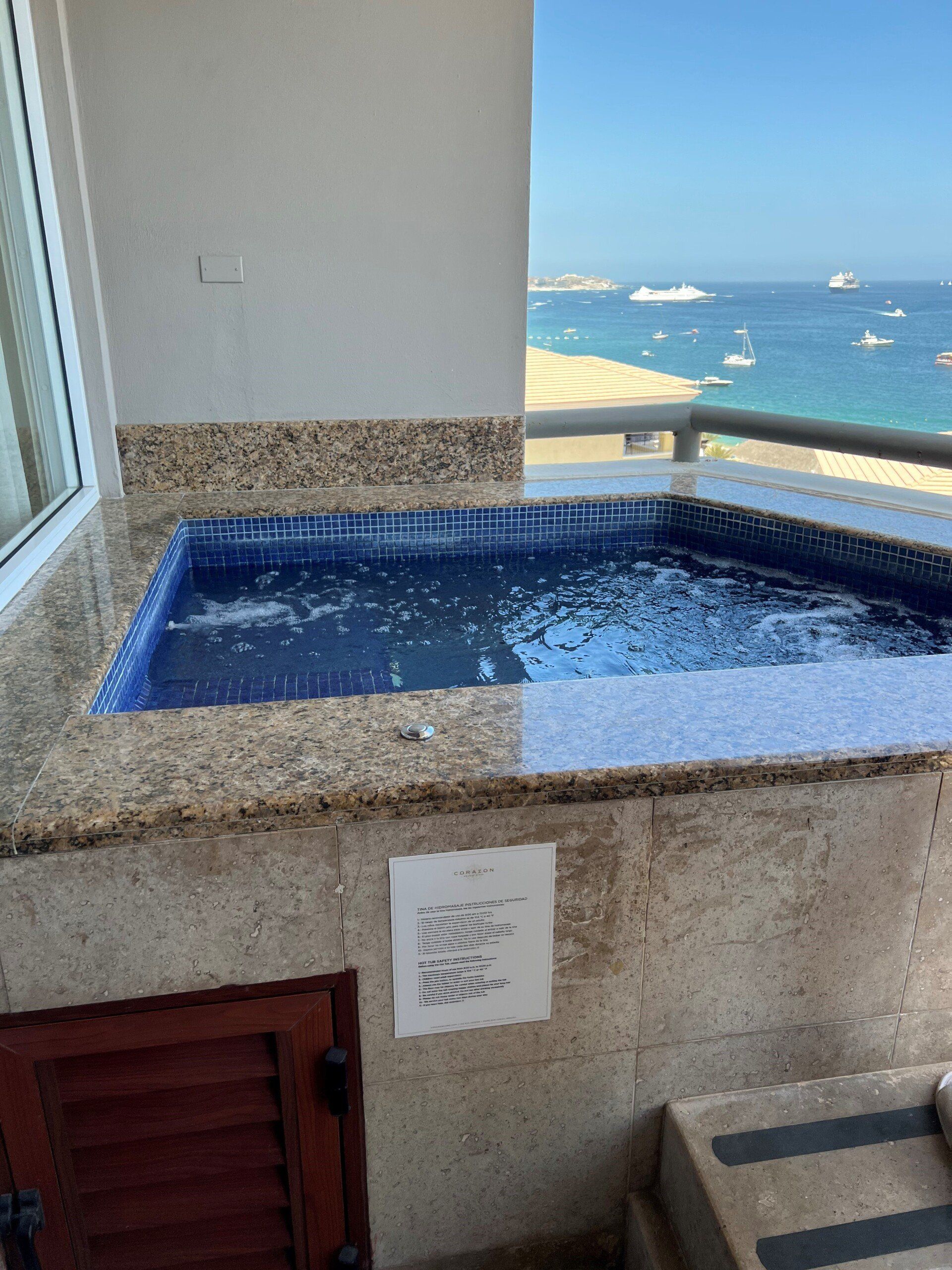 A jacuzzi on a balcony overlooking the ocean.
