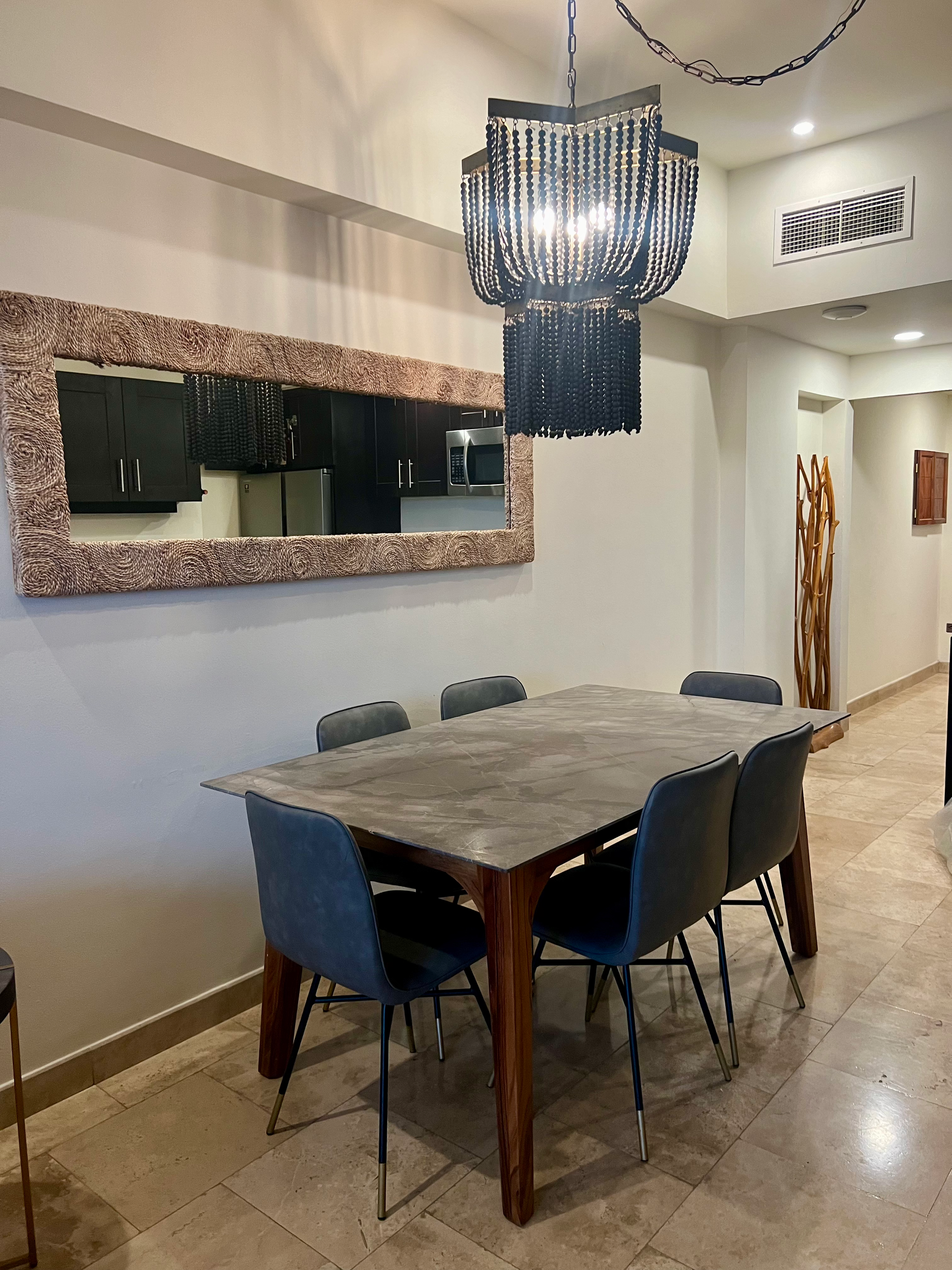 A dining room with a table and chairs and a chandelier hanging from the ceiling.