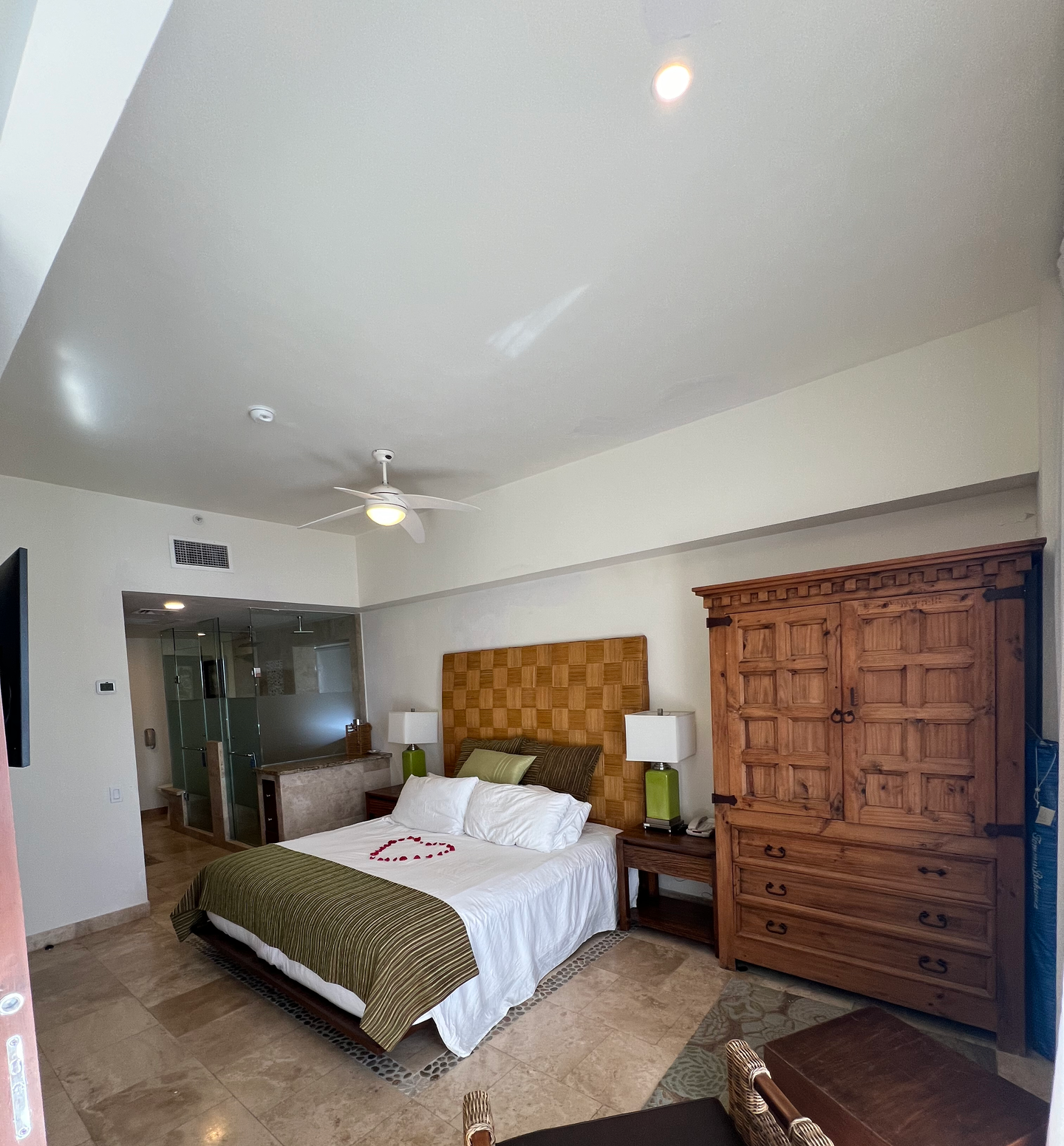 A bedroom with a large bed and a ceiling fan