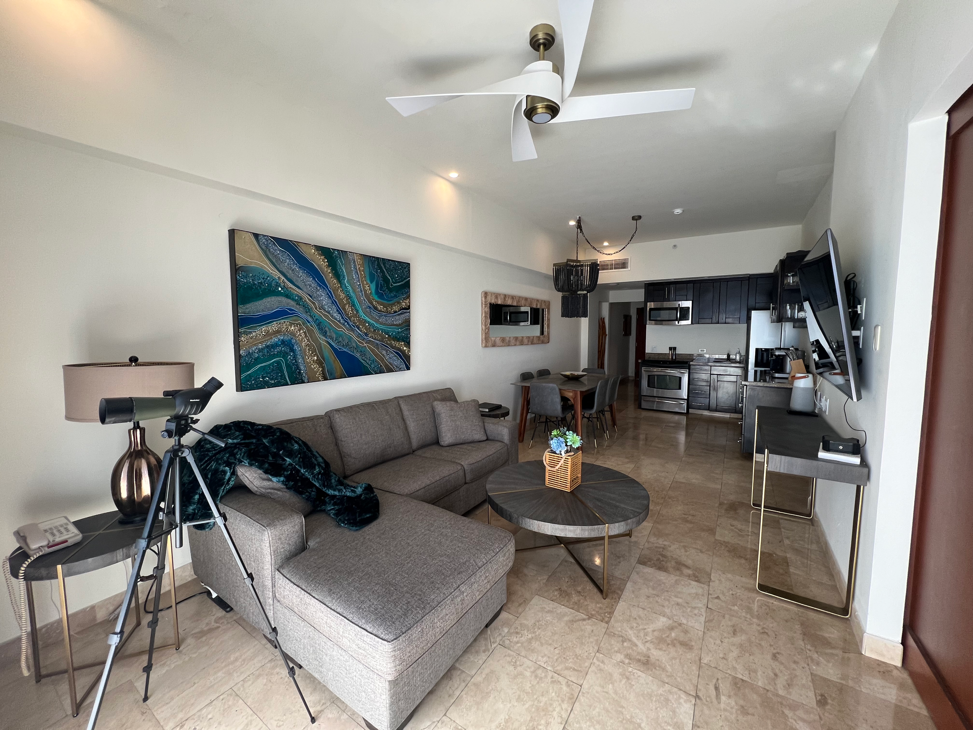 A living room with a couch , table , and ceiling fan.
