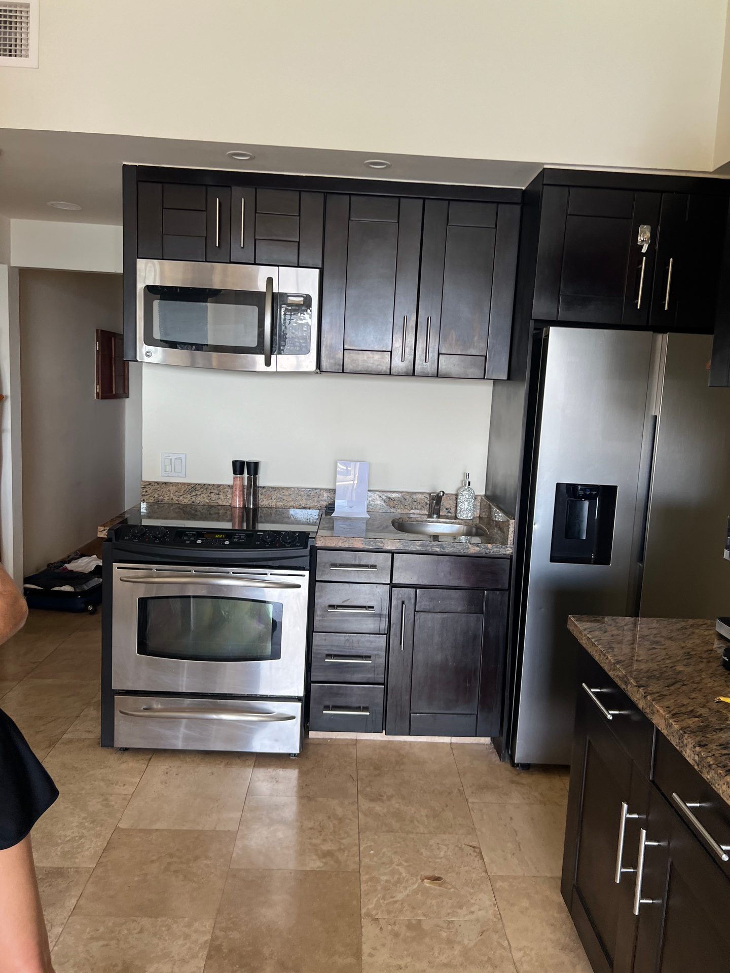 A kitchen with stainless steel appliances and black cabinets