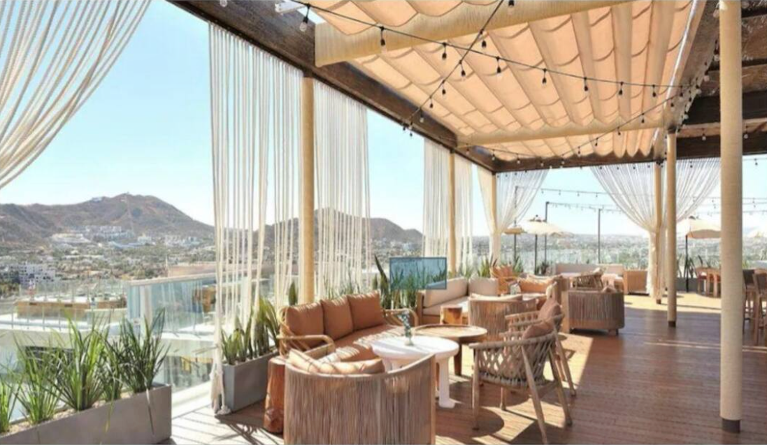 A patio with a lot of furniture and a view of a city.