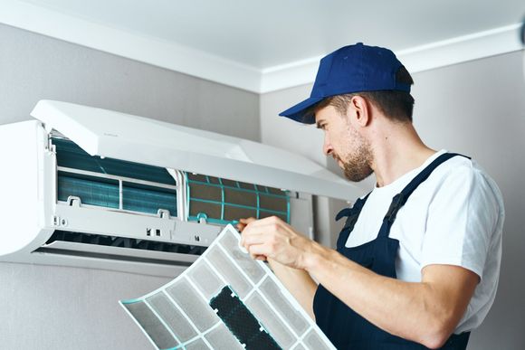 A Man Cleaning Air Filter — Oliver Springs, TN — Adkins Heating And Air