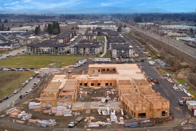 An aerial view of a large building under construction in a city.