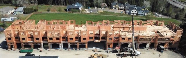 An aerial view of a building under construction in a residential area.