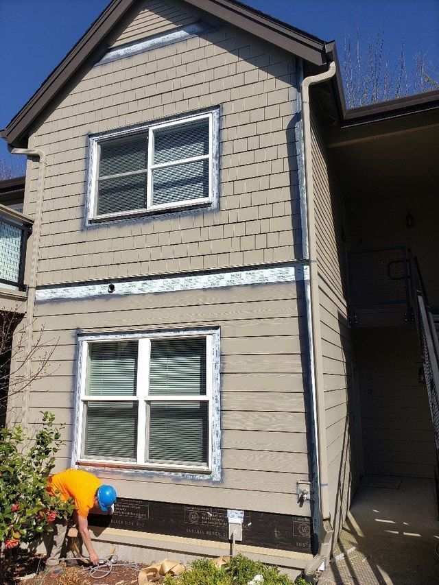 A man is working on the side of a house