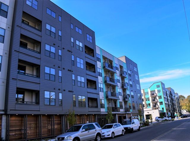 A large apartment building with cars parked in front of it