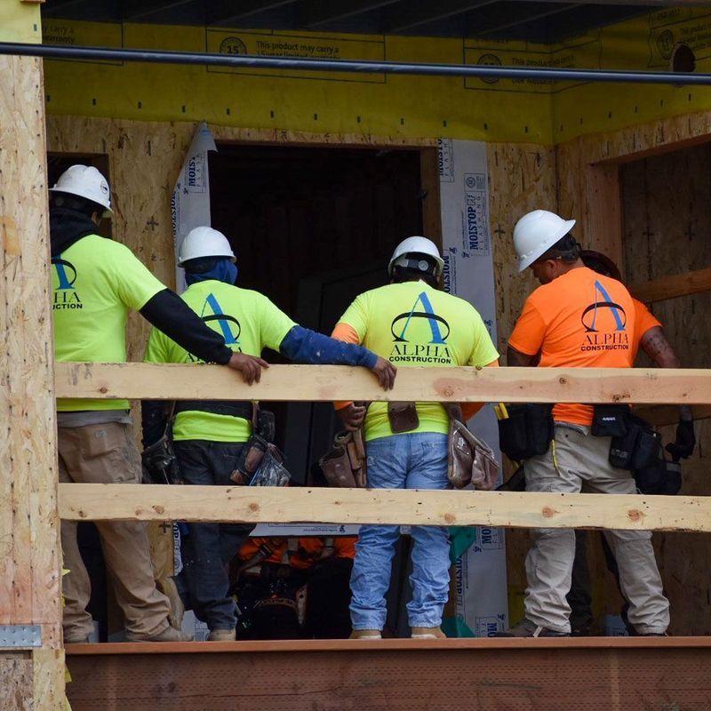 A group of construction workers wearing alpha shirts
