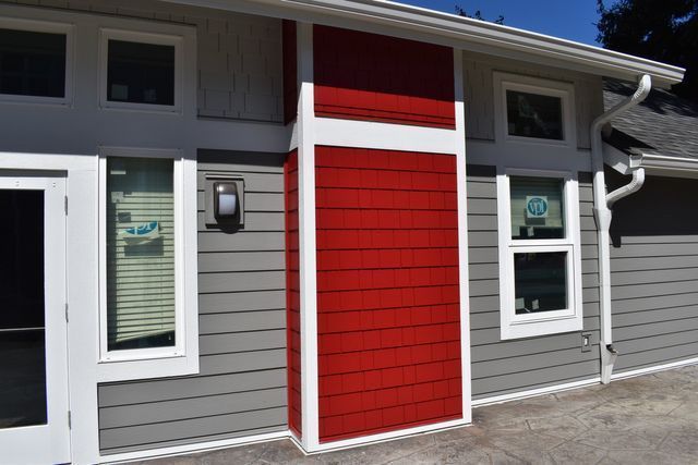A gray house with a red door and white trim