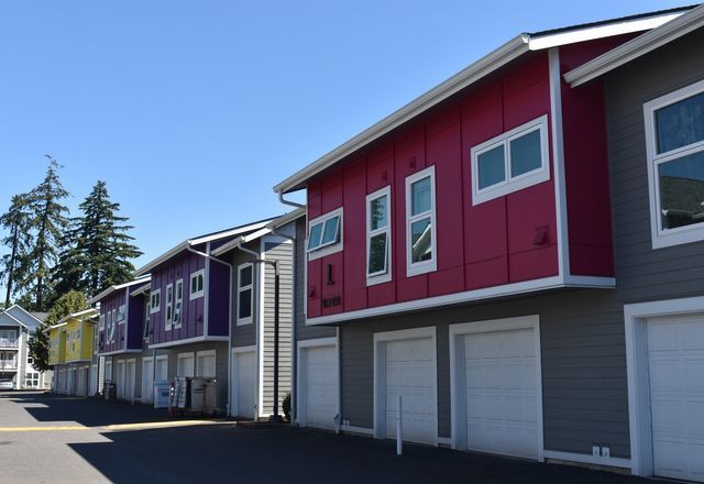 A row of colorful apartment buildings with white garage doors