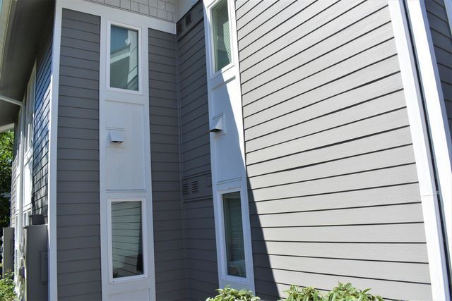 A gray and white house with a lot of windows