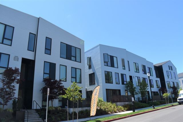 A row of white buildings with a blue sky in the background