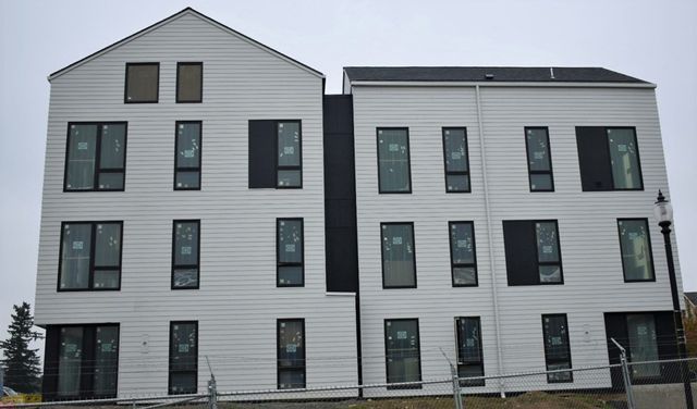 A large white building with black windows is being built.