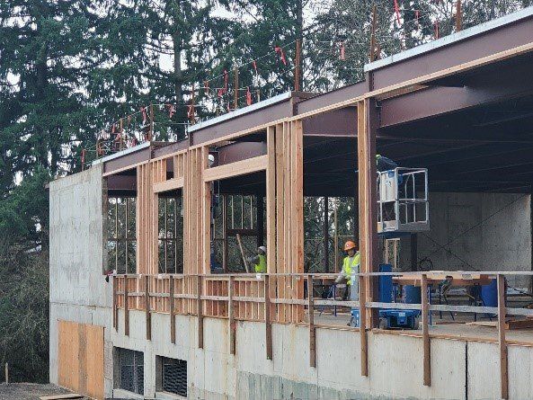 A man is standing on a balcony of a building under construction.