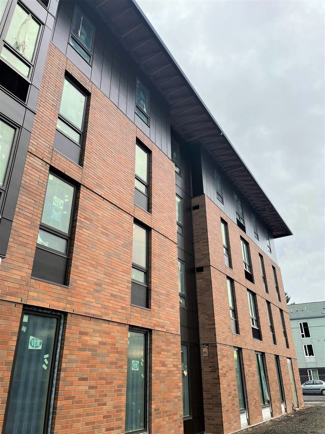 A large brick building with a lot of windows on a cloudy day.