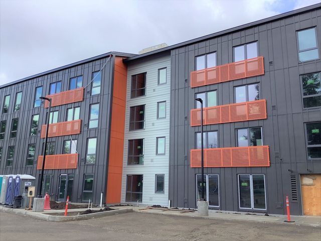 A large building with a lot of windows and balconies is under construction.