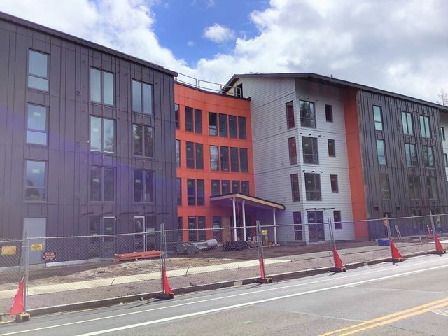 A large building is being built on the side of the road.