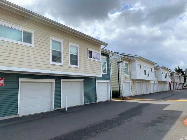 A row of apartment buildings with white garage doors.