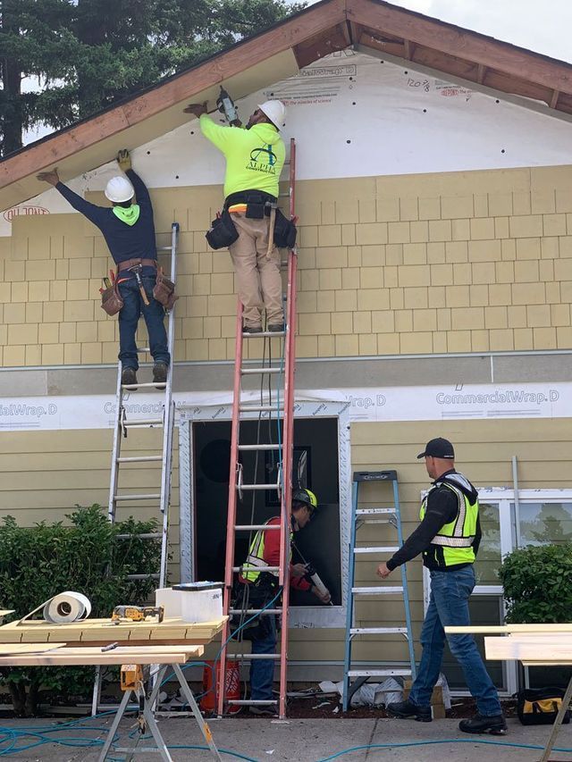 A group of construction workers are working on a house