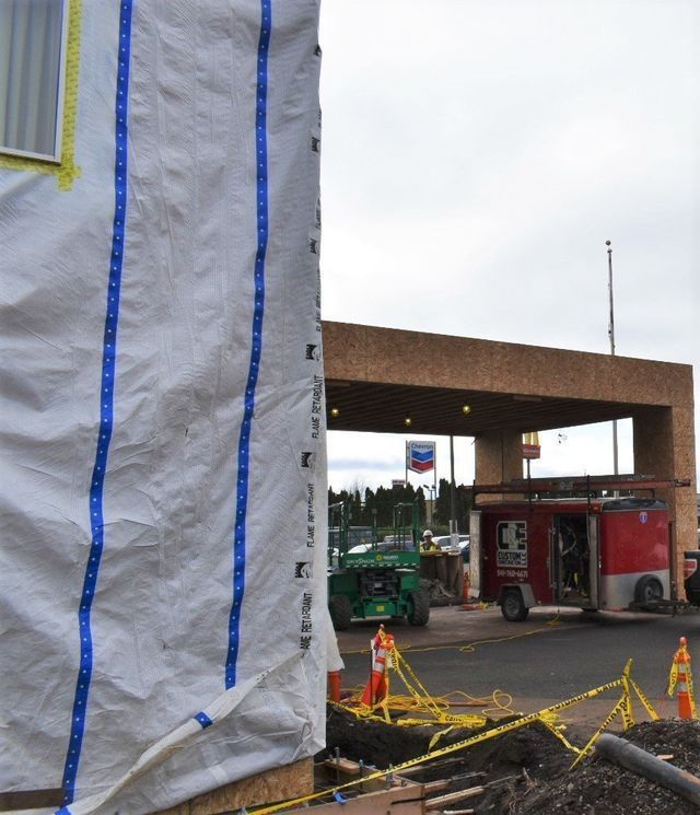 A chevron sign is on the side of a building