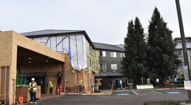 A large building is being built in a parking lot.