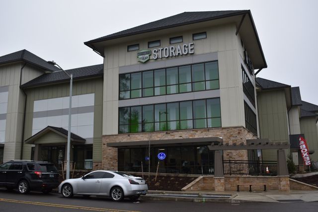A large storage building with cars parked in front of it.