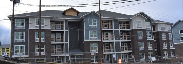 A large apartment building with a lot of windows is under construction.