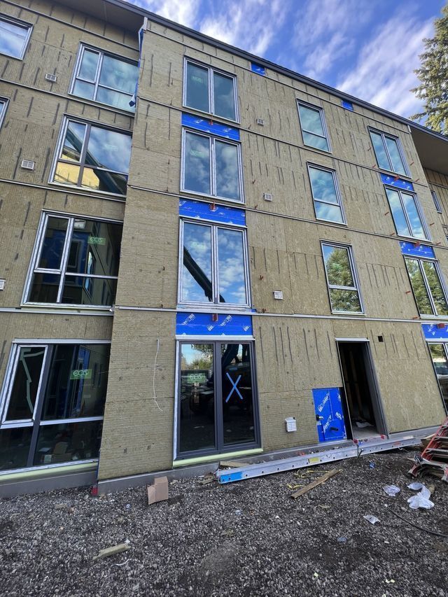A large building with a lot of windows is under construction.