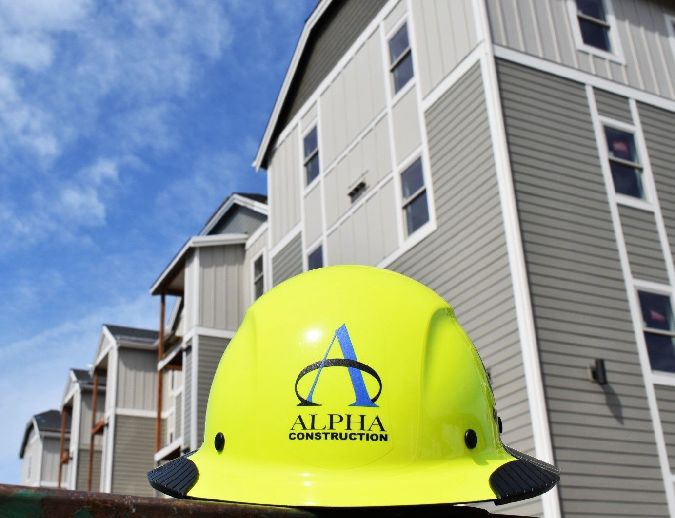 A yellow hard hat with alpha construction written on it