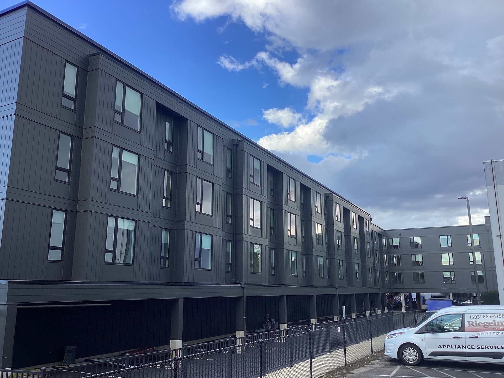 A large black building with a white van parked in front of it.