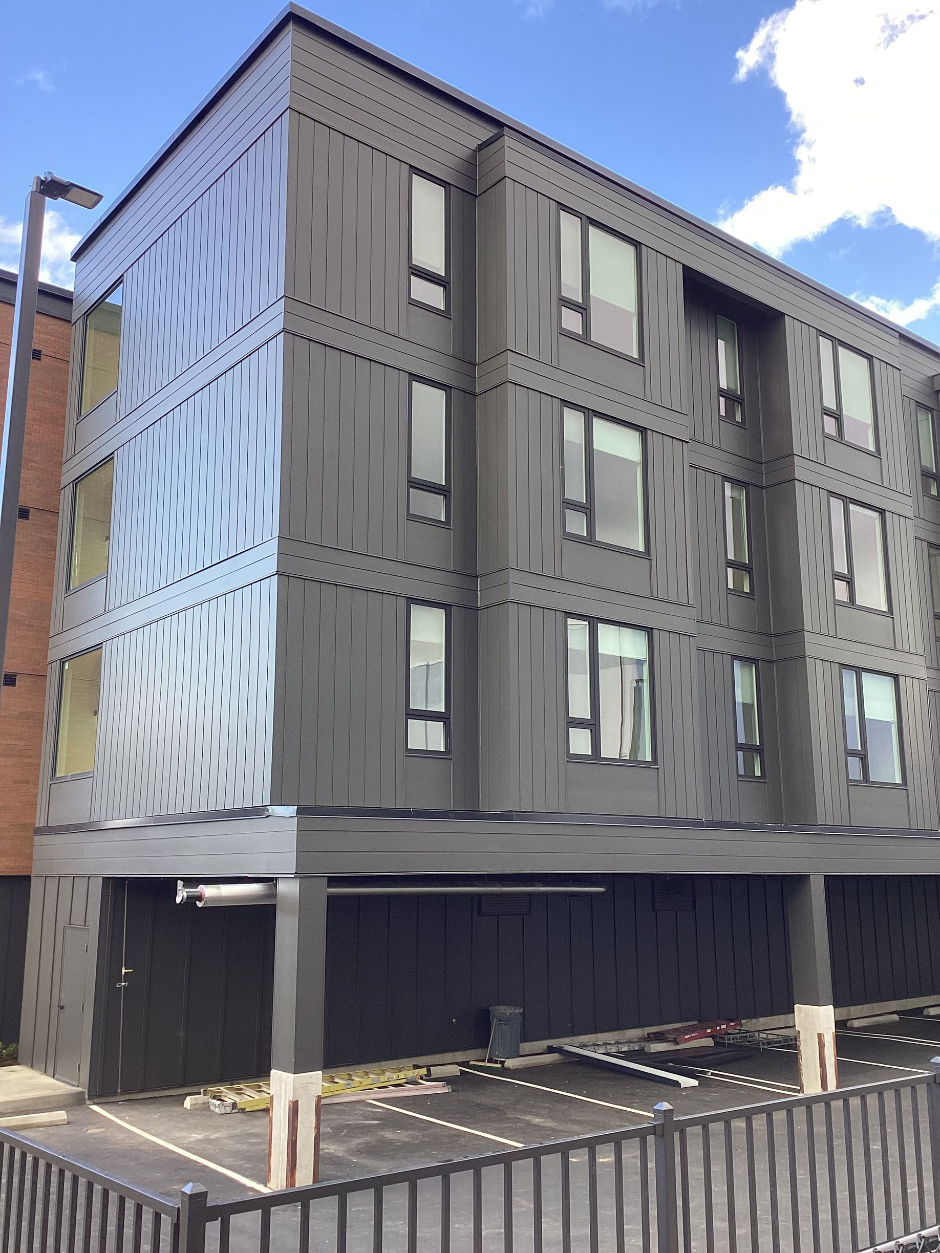 A large building with a lot of windows and a parking lot in front of it