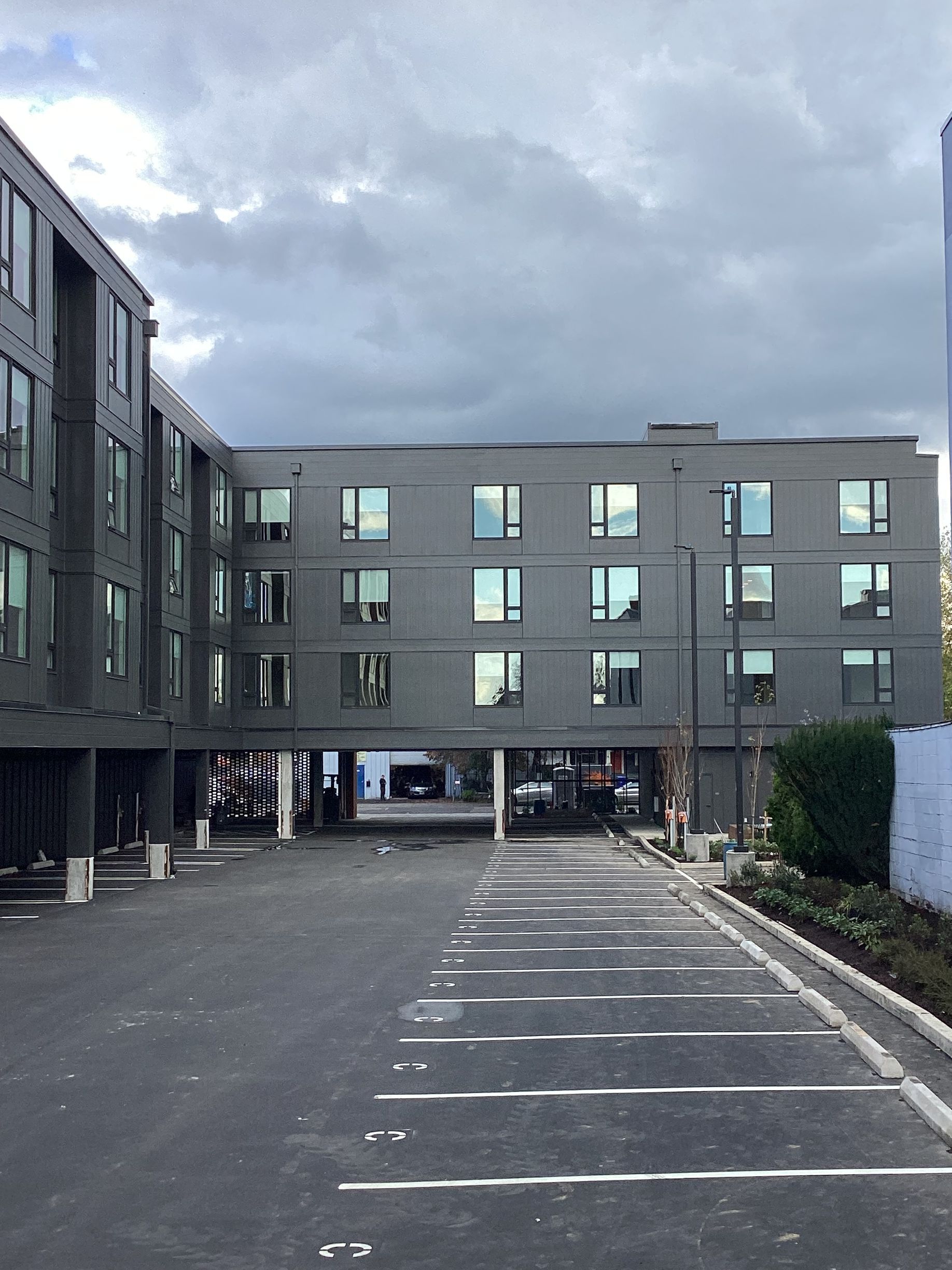 A large building with a lot of windows and a parking lot in front of it