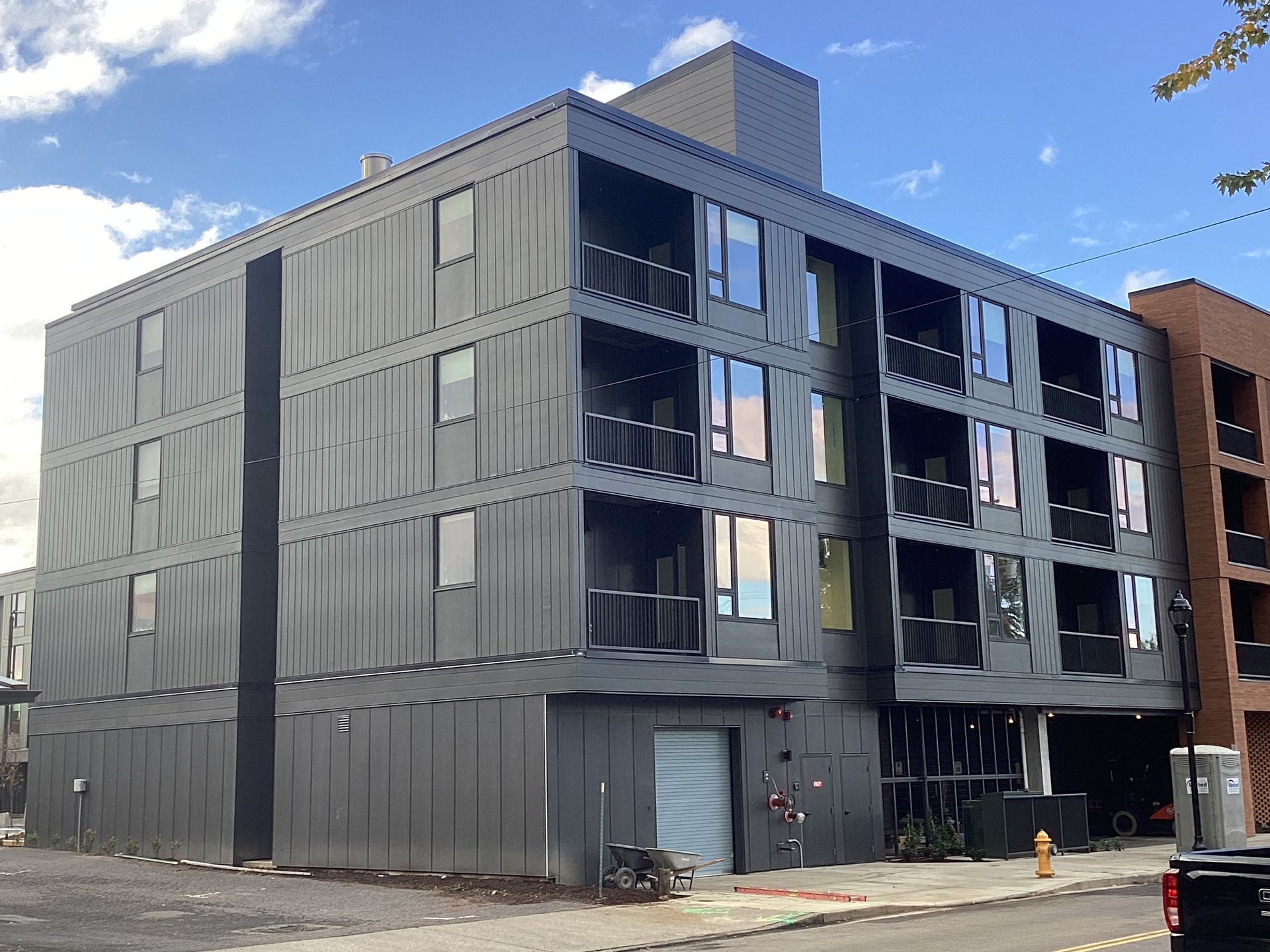 A large building with a lot of windows is sitting on the corner of a street.