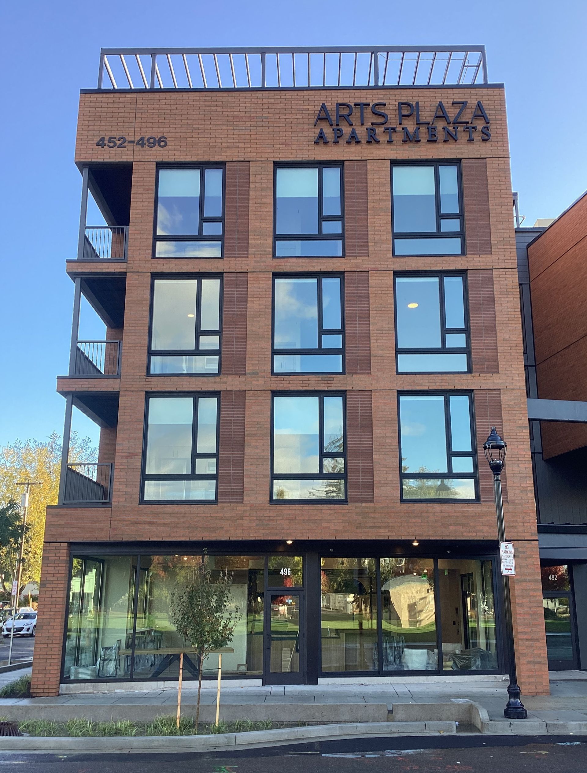 A large brick building with a sign that says arts plaza apartment
